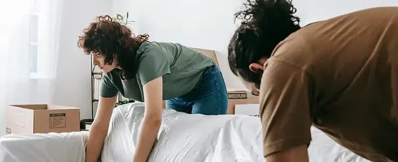 Pracownicy firmy przeprowadzkowej z kartonami przy samochodzie dostawczym